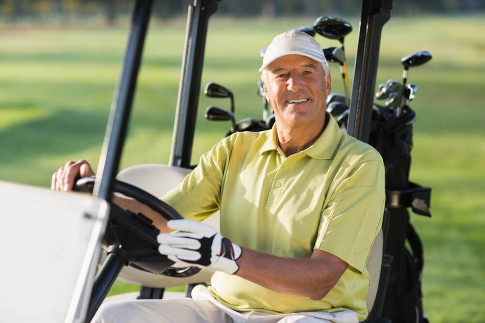 Man riding in a golf cart on golf course