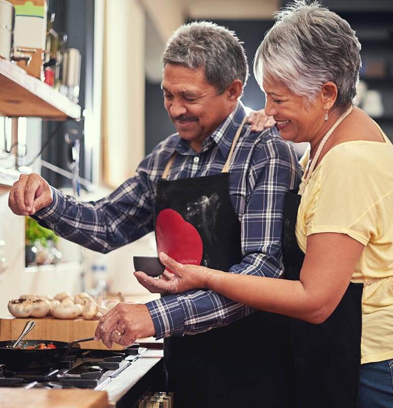 Older couple making food in a kitchen 