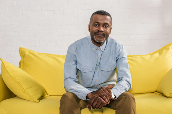 mature man sitting on yellow couch